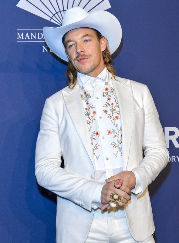 Diplo wearing a white suit and cowboy hat