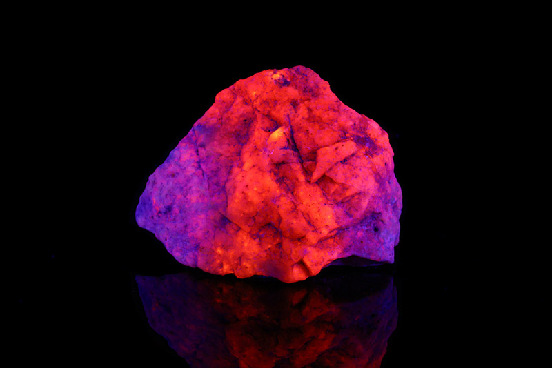 Hackmanite mineral stone under ultraviolet light