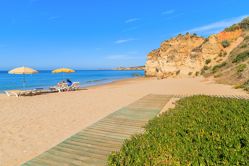 Walkway on sandy beautiful Praia da Rocha beach, Algarve region, Portugal
