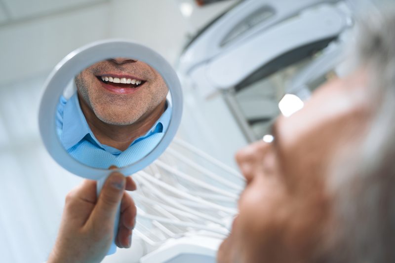 A man looking at his smile after dental procedures