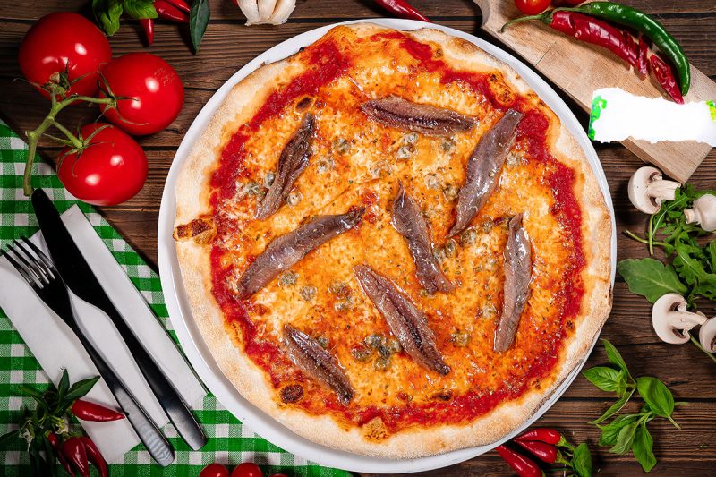 Traditional Neapolitan pizza with tomatoes and anchovies