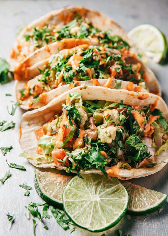 Fish tacos with lettuce, tomato, onion and avocado